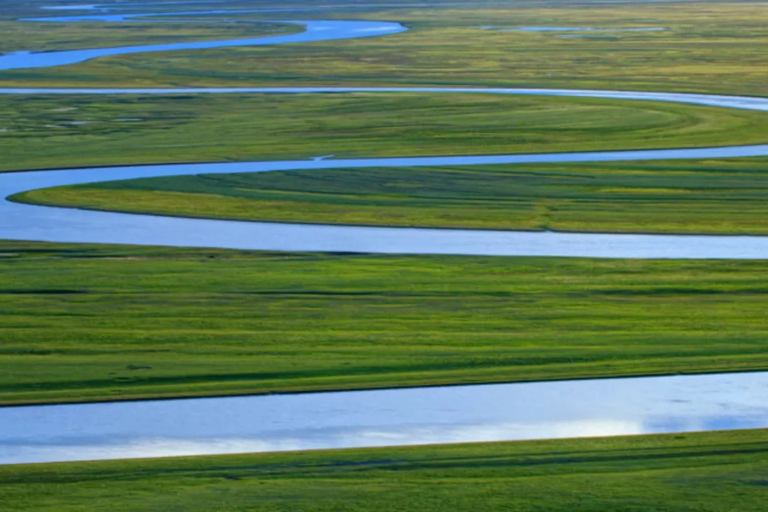 Winding blue river through green Ili grasslands